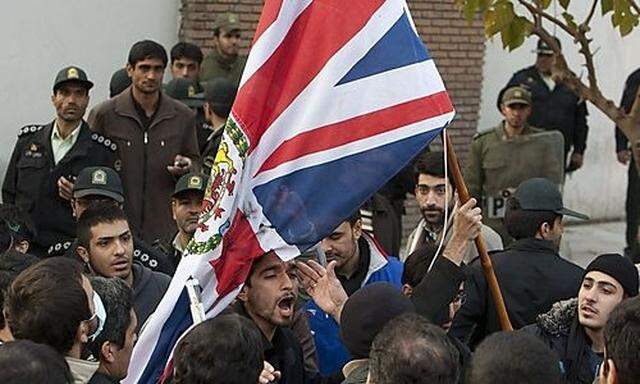 Protestors remove the flag of the British embassy in Tehran