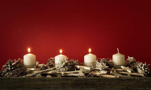Adventkranz mit drei brennenden Kerzen. 