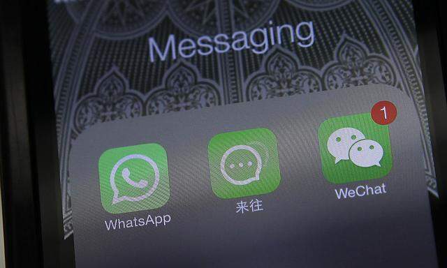 Icons of messaging applications WhatsApp, Laiwang and WeChat, or Weixin, are seen on the screen of a smart phone on this photo illustration taken in Beijing