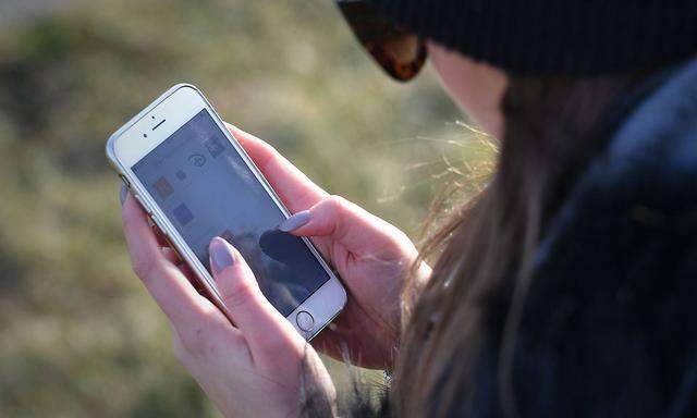 Junge Frau blickt auf ihr Smartphone Haende am Handy Bildschirm scrollen tippen Close up *** Young