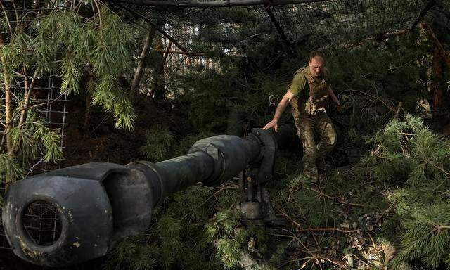 Da ist was im Busch. Ukrainischer Artillerist auf im Wald getarnter westlicher Panzerhaubitze M109, Region Donetsk.