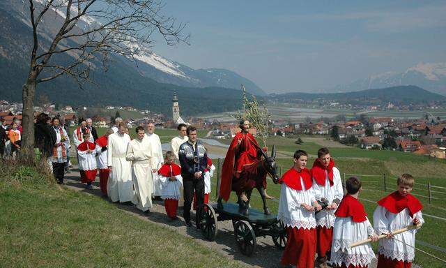 Ministranten ziehen die jahrhundertealte Holzfigur bei der Palmprozession in Thaur.