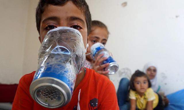 Kinder in der nordsyrischen Rebellenbastion Idlib mit improvisierten Gasmasken, die aus Getränkedosen gebastelt sind.