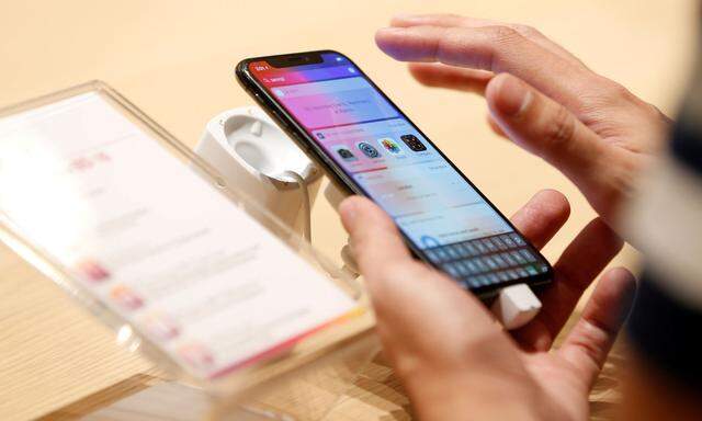 A customer tests the features of the newly launched iPhone X at VIVA telecommunication store in Manama