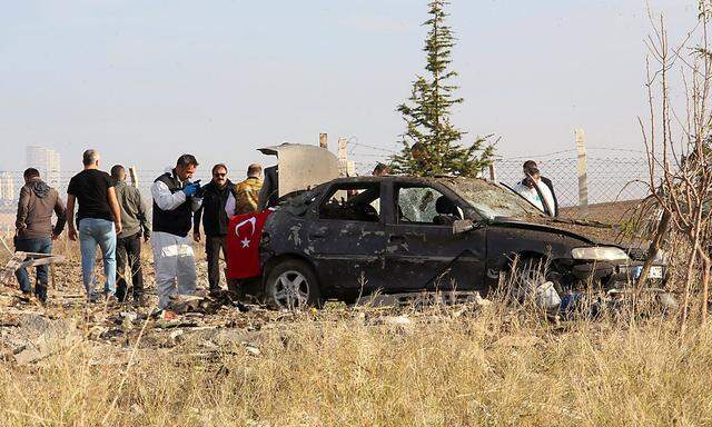 Police forensic experts examine a car after a blast detonated by two militants, in the countryside of Haymana near Ankara