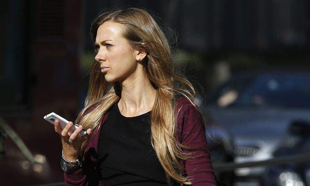 A woman uses her mobile phone on the high street in central London