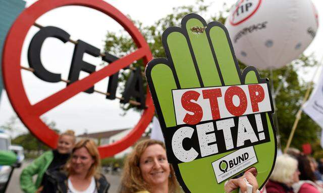 Consumer rights activists hold banners as they protest against CETA during Social Democrats meeting in Wolfsburg