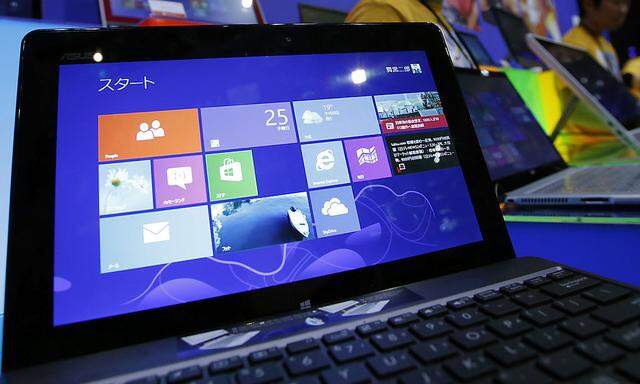 People try out Microsoft Corp´s Windows 8 operating system at an event for its debut at the Akihabara electronics store district in Tokyo