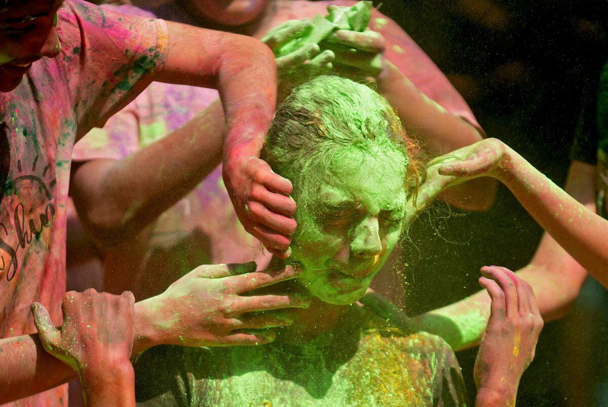 25. März. Wer bunt sein möchte, schließt in diesem Fall besser die Augen. Ein Mädchen lässt sich während der Holi-Feierlichkeiten in Mumbai, Indien, farbiges Pulver auf ihr Gesicht auftragen.

