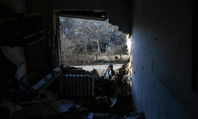 Ein Bewohner von Donezk vor einem durch Beschuss beschädigten Wohnhaus.