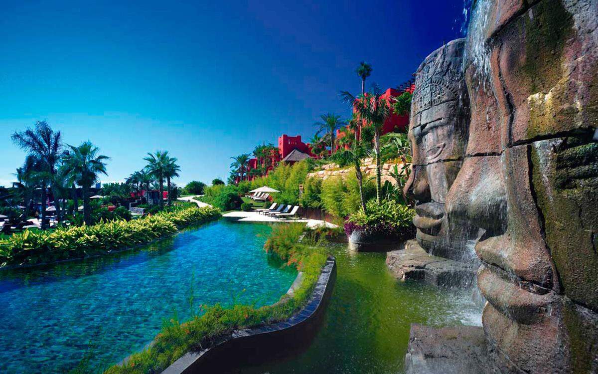 Asiatische Flora mitten in Spanien: Die fünf Pools des Hotels sind umgeben von mehr als 200 verschiedenen Baum- und Pflanzenarten, wovon 80 Prozent aus Asien stammen. Steinskulpturen und Wasserfälle runden das Badeerlebnis hier ab. 
