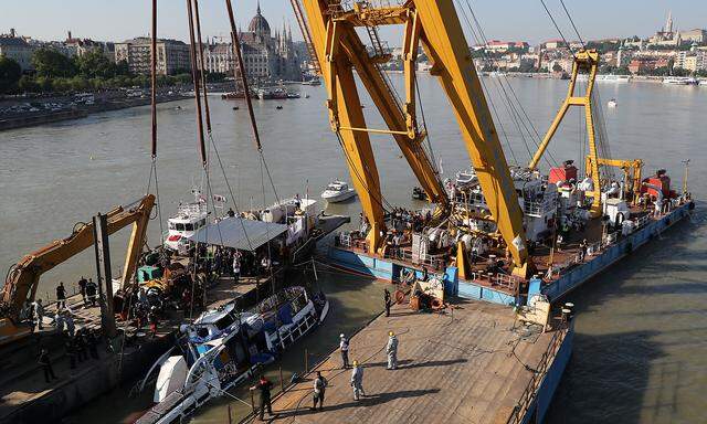 Der Bergekran hebt das Ausflugsboot aus dem Wasser