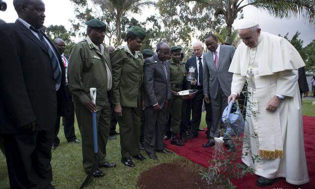 Pope Francis waters a plant next to Kenya's President Uhuru Kenyatta during a ceremony at the State House in Kenya's capital Nairobi