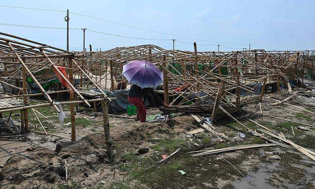 Eine Frau versucht, Trümmer im Flüchtlingslager Pyone Yay im vom Zyklon "Mocha" schwer getroffenen burmesischen Bundessstaat Rakhine zu beseitigen.