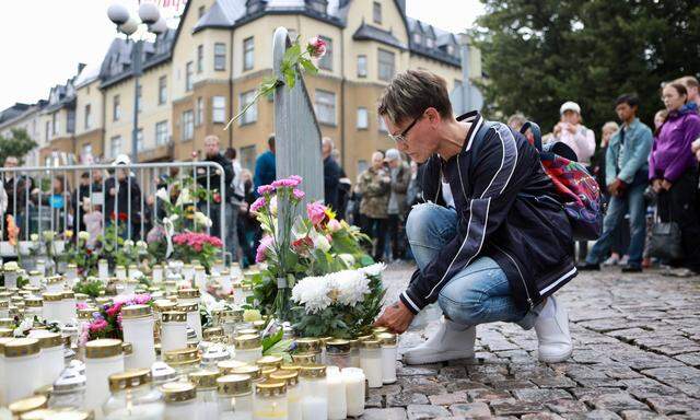 Eine Frau legte am Sonntag Blumen für die Opfer am Markt von Turku nieder.