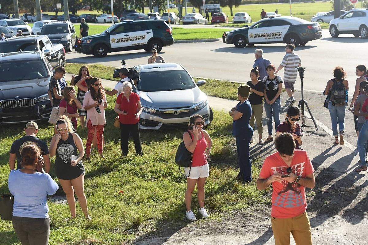 Besorgte Eltern vor der Marjory Stoneman Douglas High School in Parkland, Florida: Im Schulgebäude selbst richtete ein 19-jähriger gerade ein Blutbad an. Offenbar löste der Ex-Schüler  einen Feueralarm aus. Unter einer Gasmaske geschützt habe er Rauchbomben gezündet und dann das Feuer auf die fliehenden Schüler und Lehrer eröffnet, schildern  Augenzeugen. Einige Schüler schrieben ihren Eltern Nachrichten aufs Handy: "Was soll ich tun, wo soll ich hin?"