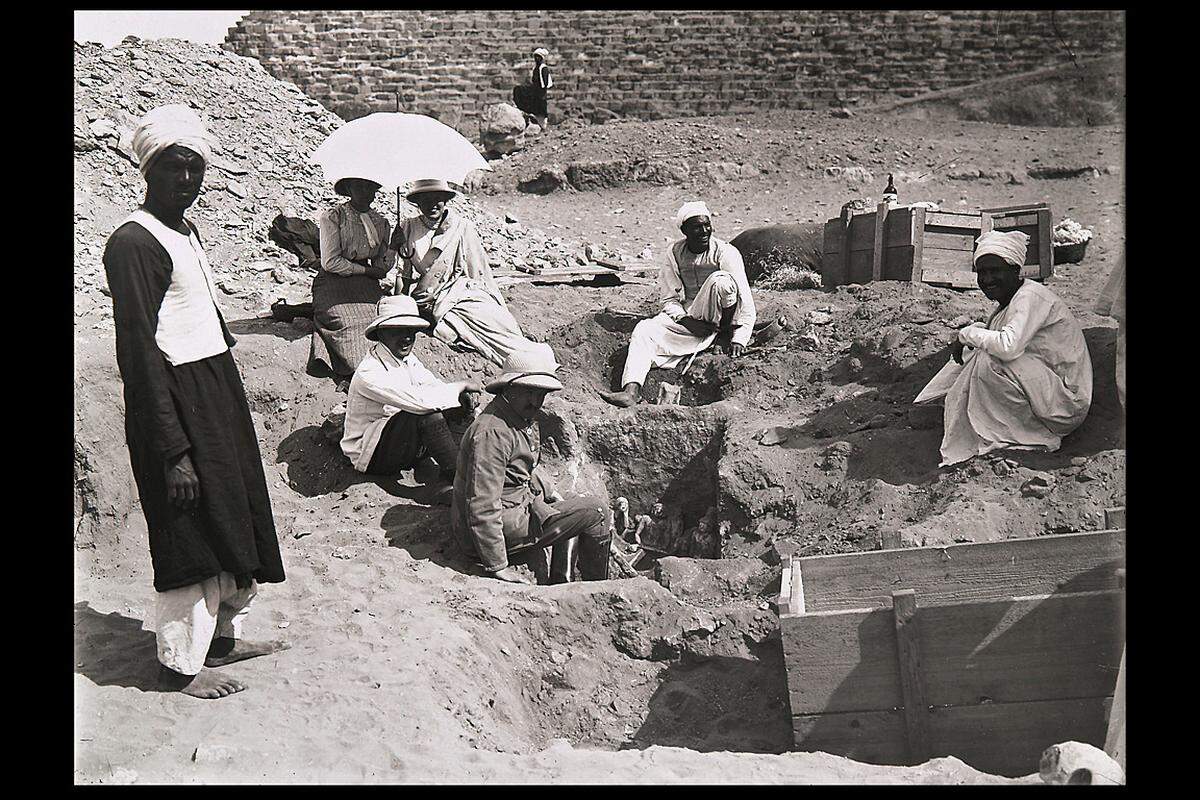 Mit Unterstützung von rund 200 ägyptischen Arbeitern wurden Privatgräber, vorzugsweise im Mastaba-Stil erbaut, untersucht.  Im Bild: Der Ausgräber Hermann Junker, (im Vordergrund sitzend mit Tropenhelm) und sein Team bei der Freilegung von Statuen aus der Mastaba des Schepsesptah, 1913, (c) Kunsthistorisches Museum Wien