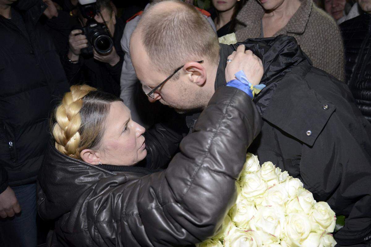 Der Fraktionschef von Timoschenkos Vaterlandspartei, Arseni Jazenjuk, überreicht der Regierungschefin zum Wiedersehen Blumen.