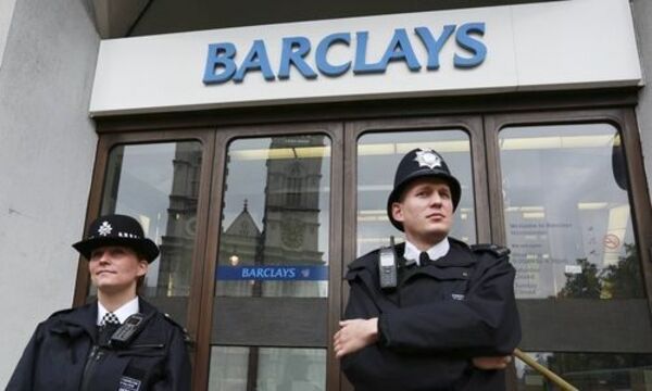 Police wait for protestors to appear at a branch of Barclays Bank in Westminster, central London