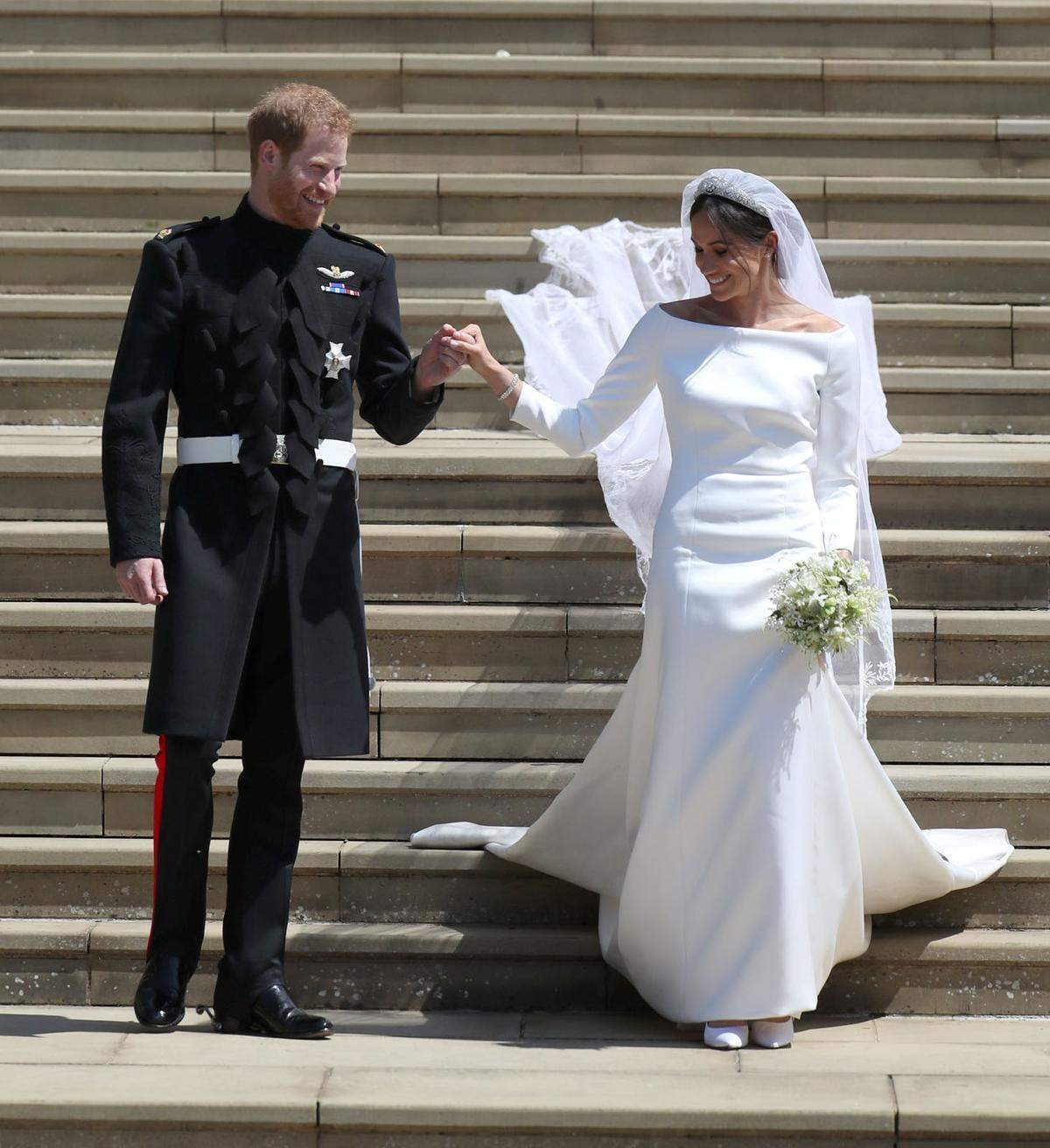 Das taillierte und in einer kleinen Schleppe auslaufende Kleid hat einen Unterrock aus matt schimmernder dreifach übereinander gelegter Organza.