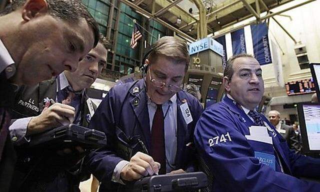 In this Feb. 1, 2011 photo, traders gather at a post on the floor of the New York Stock Exchange. (AP