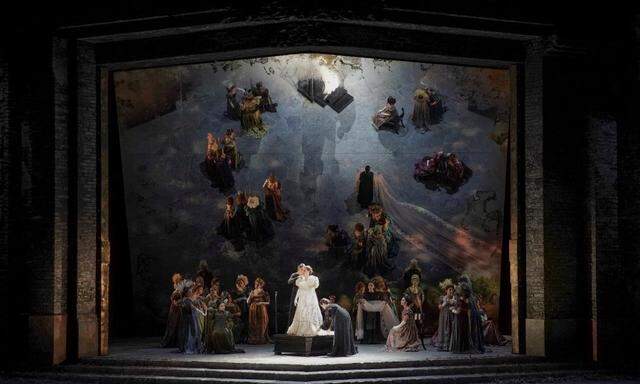 Ein geneigter Spiegel als Bühnenhintergrund sowie opulente historische Kostüme sorgen bei dieser Medea in der Athener Oper für einen malerischen Effekt.