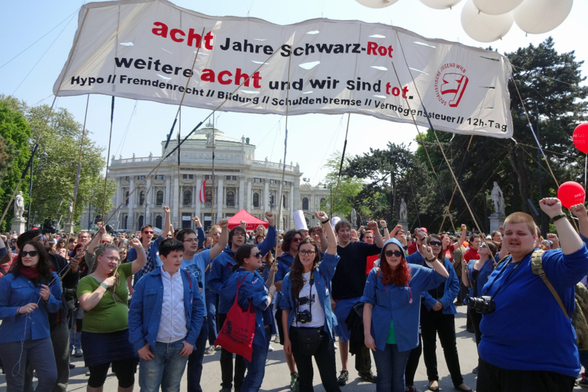 Doch nicht alle lassen sich von der Begeisterung anstecken: „Acht Jahre Schwarz-Rot, weitere acht und wir sind tot", lautet die Botschaft dieser Demonstranten, die sich am Rathausplatz unter die Menge gemischt haben. Der Umgang mit „Hypo, Fremdenrecht, Bildung, Schuldenbremse und Vermögenssteuern" stoßen ihnen sauer auf.