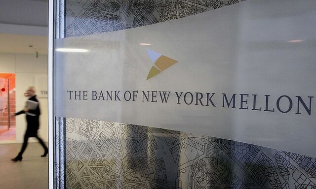 A woman walks past a logo at the office of the Bank of New York Mellon in Brussels
