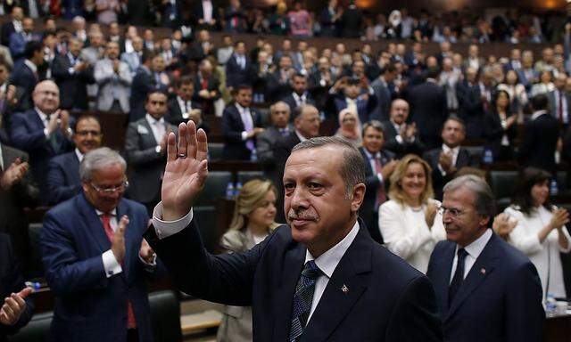 Turkey's Prime Minister Tayyip Erdogan greets members of parliament from his ruling AK Party (AKP) as he arrives for a meeting at the Turkish parliament in Ankara