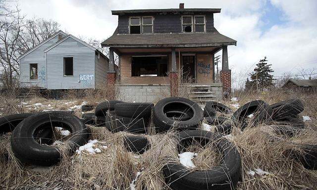 Ilegally dumped tires sit in front of a vacant, blighted home in a once thriving neighborhood on the east side of Detroit