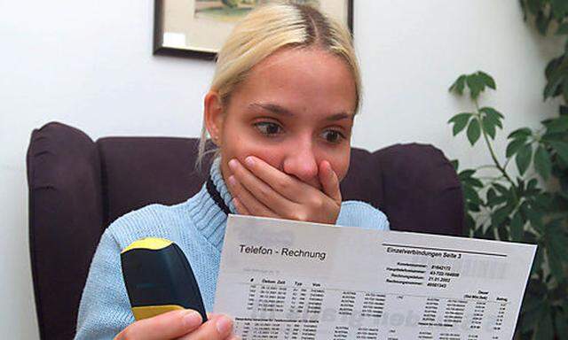 Junge Frau erschrickt ueber hohe Telefonrechnung