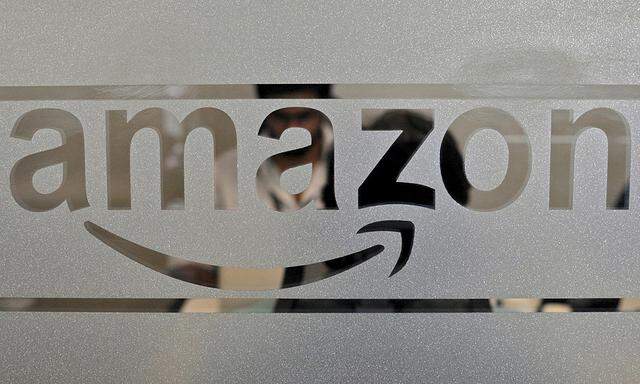 File photo of employees of Amazon India are seen behind a glass bearing the company´s logo inside its office in Bengaluru