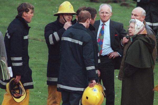 1992, das Schreckensjahr. Prinz Andrew und Ehefrau Sarah trennen sich, nachdem Oben-ohne-Fotos von Sarah kursierten. Prinzessin Anne lässt sich scheiden. Dann brannte es auf Schloss Windsor (im Bild: die Königin wird von der Feuerwehr über die Löscharbeiten informiert). Und Charles und Diana geben ihre Trennung bekannt.