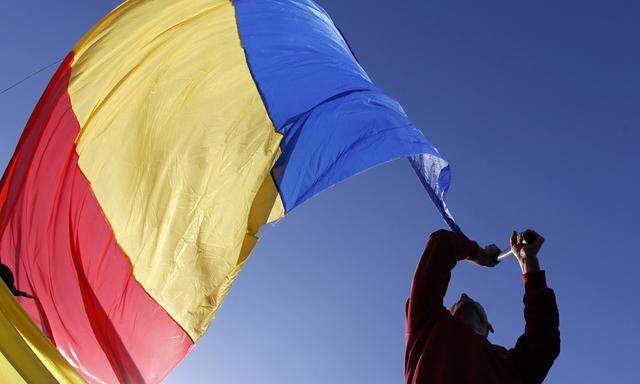 Man waves a Romanian national flag during a march in downtown Bucharest