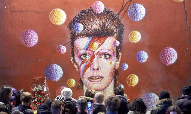 Vor einem Bild von David Bowie als Aladdin Sane: Trauernde in Brixton, London.