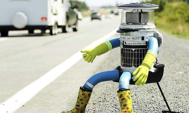 The anthropomorphic robot named hitchBOT sits on the shoulder of Highway 102 to begin its 6000 kilometer cross country journey outside of Halifax