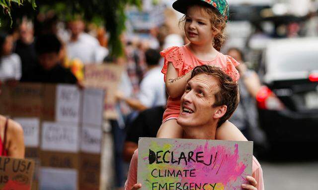 In Australien und Thailand wird bereits seit einigen Stunden protestiert. Dieser Umweltaktivist trägt seine Tochter durch eine Demonstration nahe des Umweltministeriums von Bangkok. 
