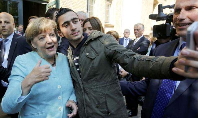 Anas Modamani mit Angela Merkel