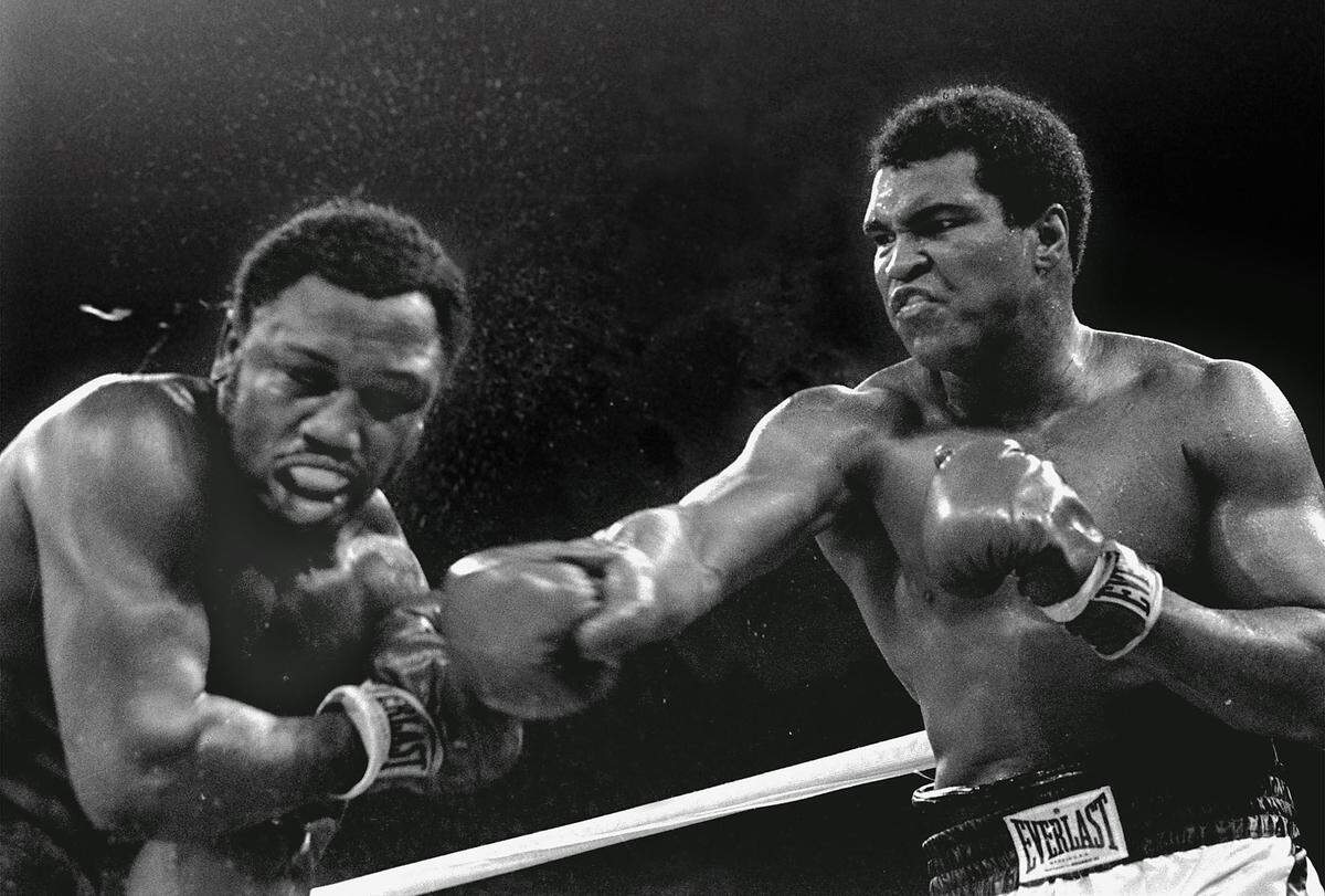 Joe Frazier kassiert einen schweren Haken, Champion Muhammad Ali hat beim Titelkampf in Manila am 1. Oktober 1975 seine Rechte besser im Einsatz. "In der Hitze des Gefechtes habe ich einige Dinge gesagt, die ich nicht haette sagen sollen" erklärte Ali 25 Jahre später. Frazier soll die Entschuldigung schon angenommen haben. Nach dem "Thrilla in Manilla" mussten beide mehrere Wochen im Krankenhaus verbringen.