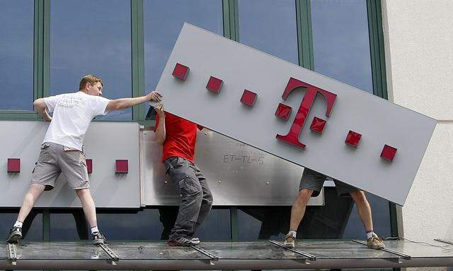 File photo of T-Mobile logo being positioned on a shop front