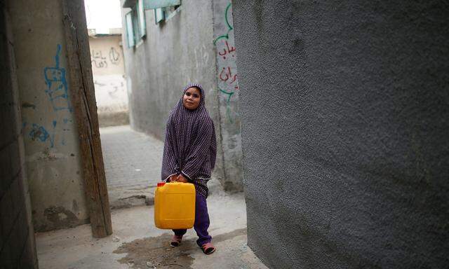 Ein Mädchen trägt Wasser in einem Plastikbehälter