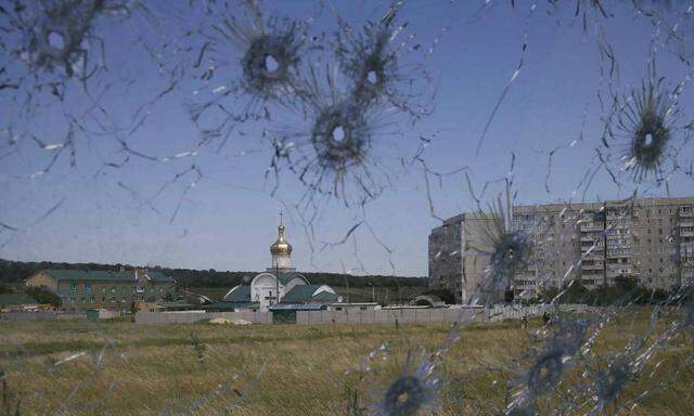 A Ukrainian border post is seen through bullet holes in a truck's windscreen on the outskirts of the eastern Ukrainian city of Luhansk