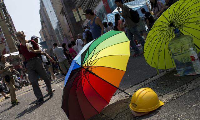 An umbrella and a security helmet is seen on a main road at the Mong Kok shopping district in Hong Kong