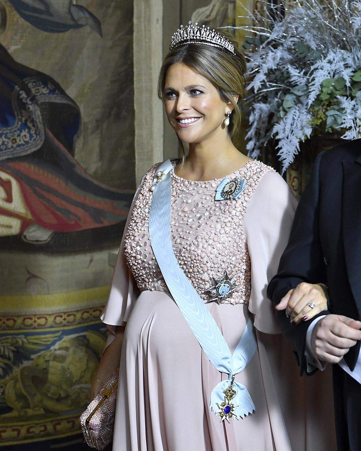 Tatsächlich war die roséfarbene Robe vom libanesischen Couturier Elie Saab eine Wiederholung: Die Prinzessin hatte sie schon 2015, ebenfalls schwanger, zur Hochzeit ihres Brudes Prinz Carl Philip getragen. Sogar mit derselben Tiara. Dieses moderne Krönchen stammt aus dem Privatbesitz der Königsfamilie - und ist bei Prinzessin Madeleine besonders beliebt: Sie trägt sie nicht nur oft, sondern wählte sie sogar für ihre eigene Hochzeit.