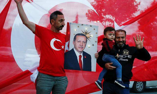 A supporter of AK Party holds a picture of Turkish President Tayyip Erdogan outside the party's headquarters in Istanbul