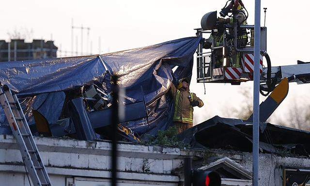 Rescue workers cover the wreckage of a police helicopter which crashed onto the roof of the Clutha Vaults pub in Glasgow, Scotland