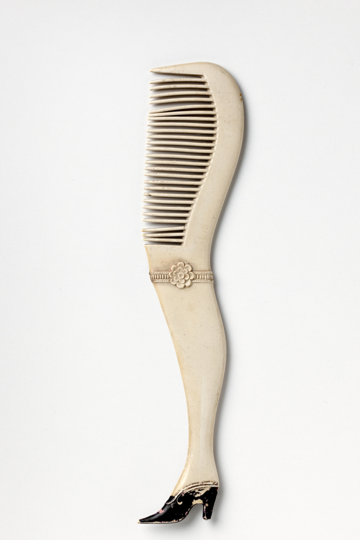 Schnurrbartkamm in Gestalt eines Frauenbeins, Herkunft unbekannt, um 1900.