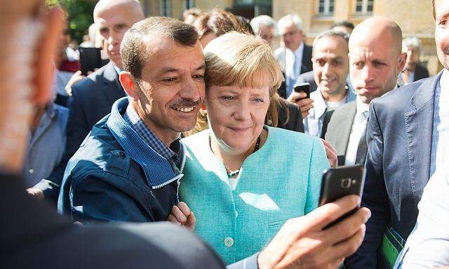 Ein Asylwerber schießt ein Selfie mit Kanzlerin ngela Merkel