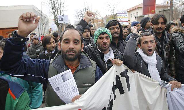 Refugees shout slogans during a protest by asylum seekers in the Austrian village of Traiskirchen