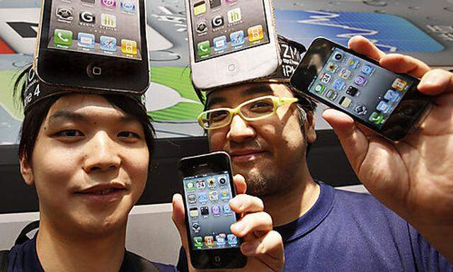 IPhone fans Mitsuru Endo, left, and Ryota Musha show the Apples latest iPhone 4 during its launch ats latest iPhone 4 during its launch at